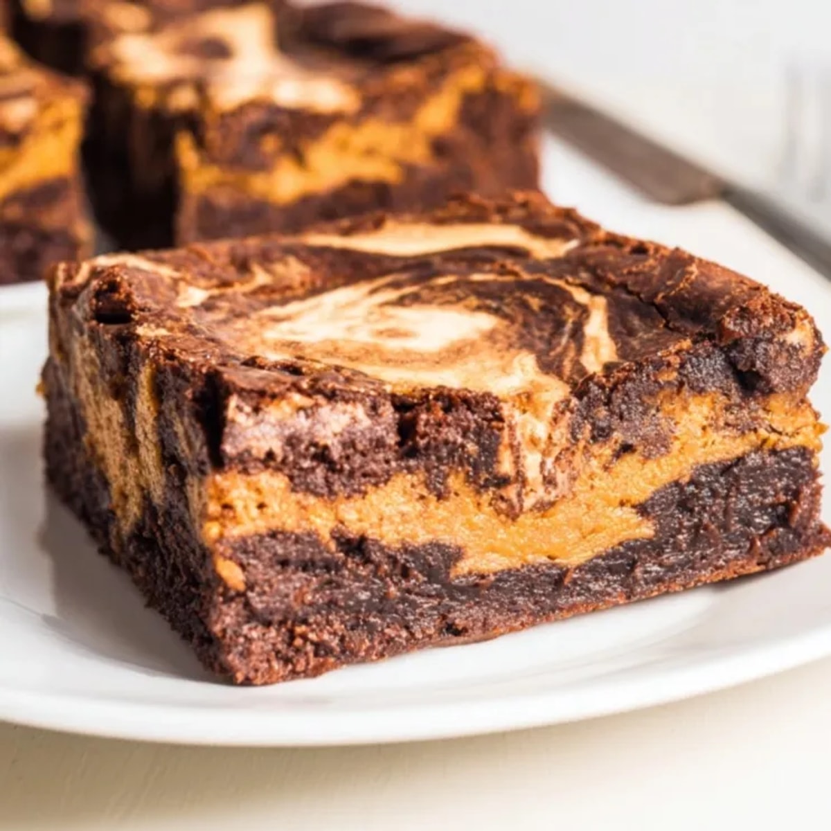 Top-down view of fudgy Pumpkin Pie Swirl Brownies, ready to cut and serve warm.