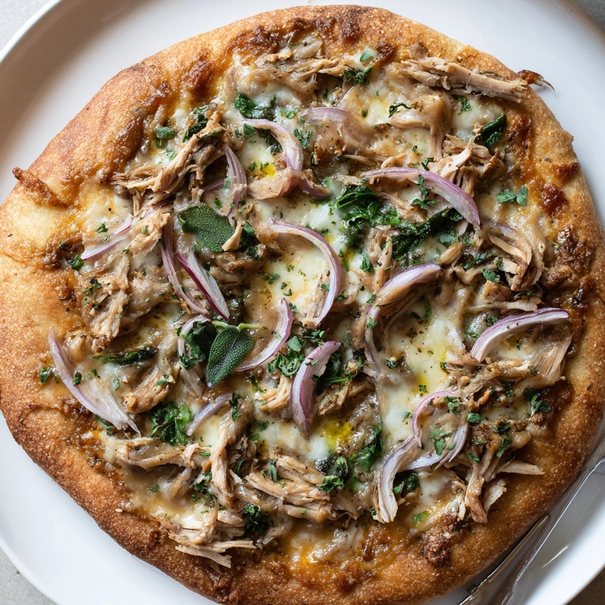Close-up of a golden Sage Turkey Gravy Pizza; creamy gravy and melted cheese.