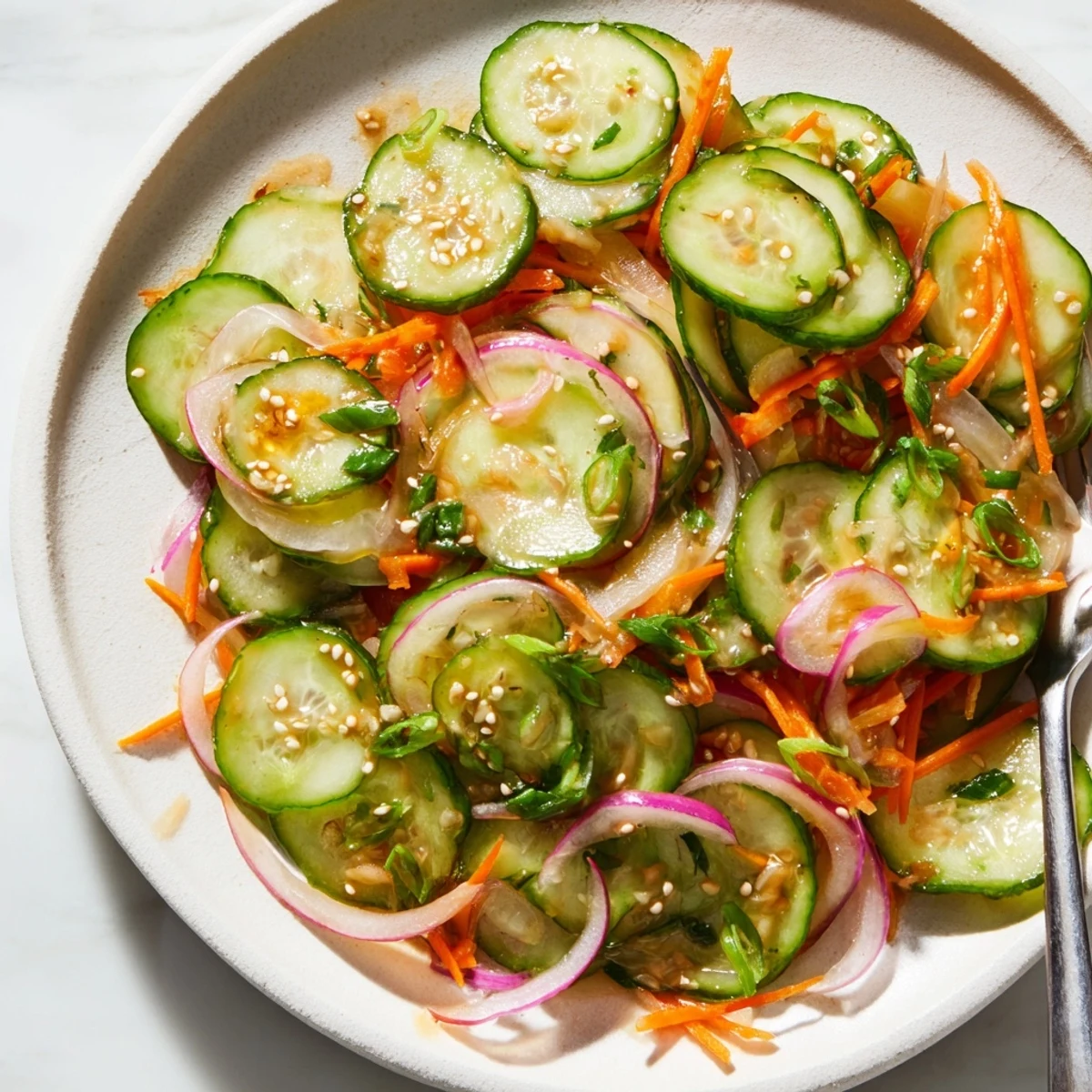 Vibrant cucumber salad remix with tangy dressing and colorful veggies awaits serving.  