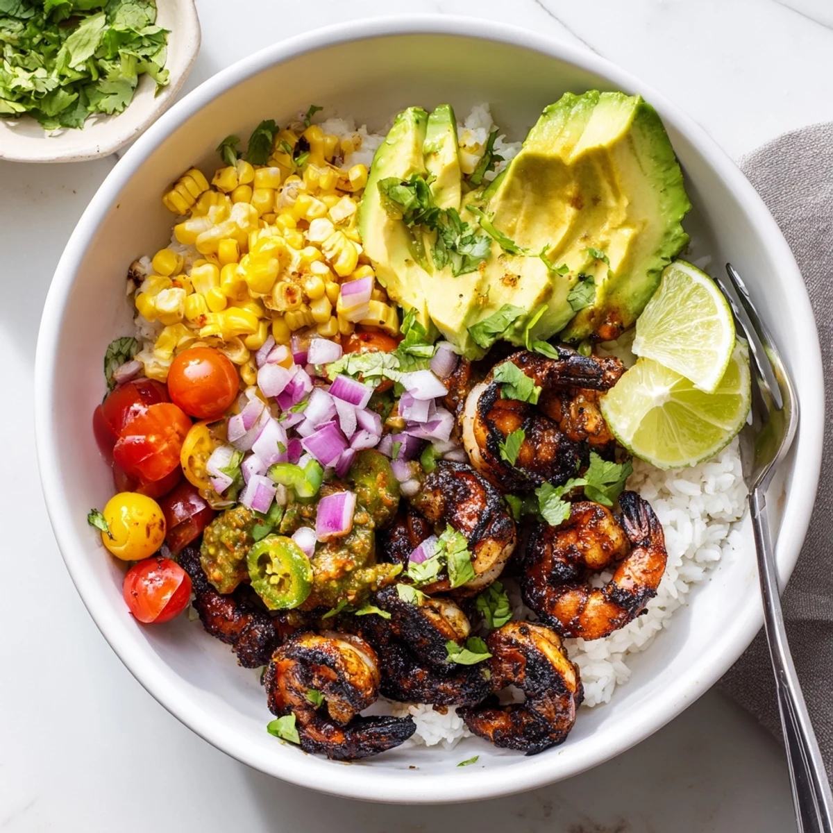 Savory blackened shrimp bowl topped with creamy avocado corn salsa and fluffy rice.  