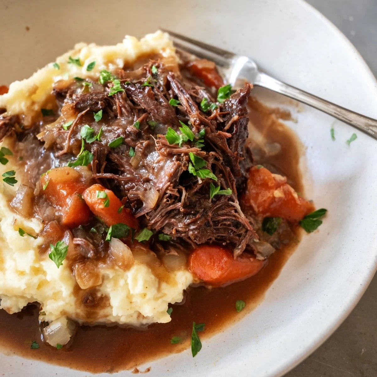 Slow Cooker Pot Roast with Mashed Potatoes served with rich gravy and fresh herbs.  