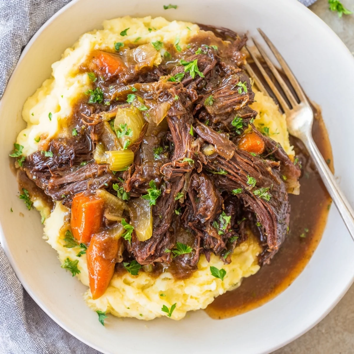 Aromatic Slow Cooker Pot Roast garnished with parsley, nestled on buttery mashed potatoes.