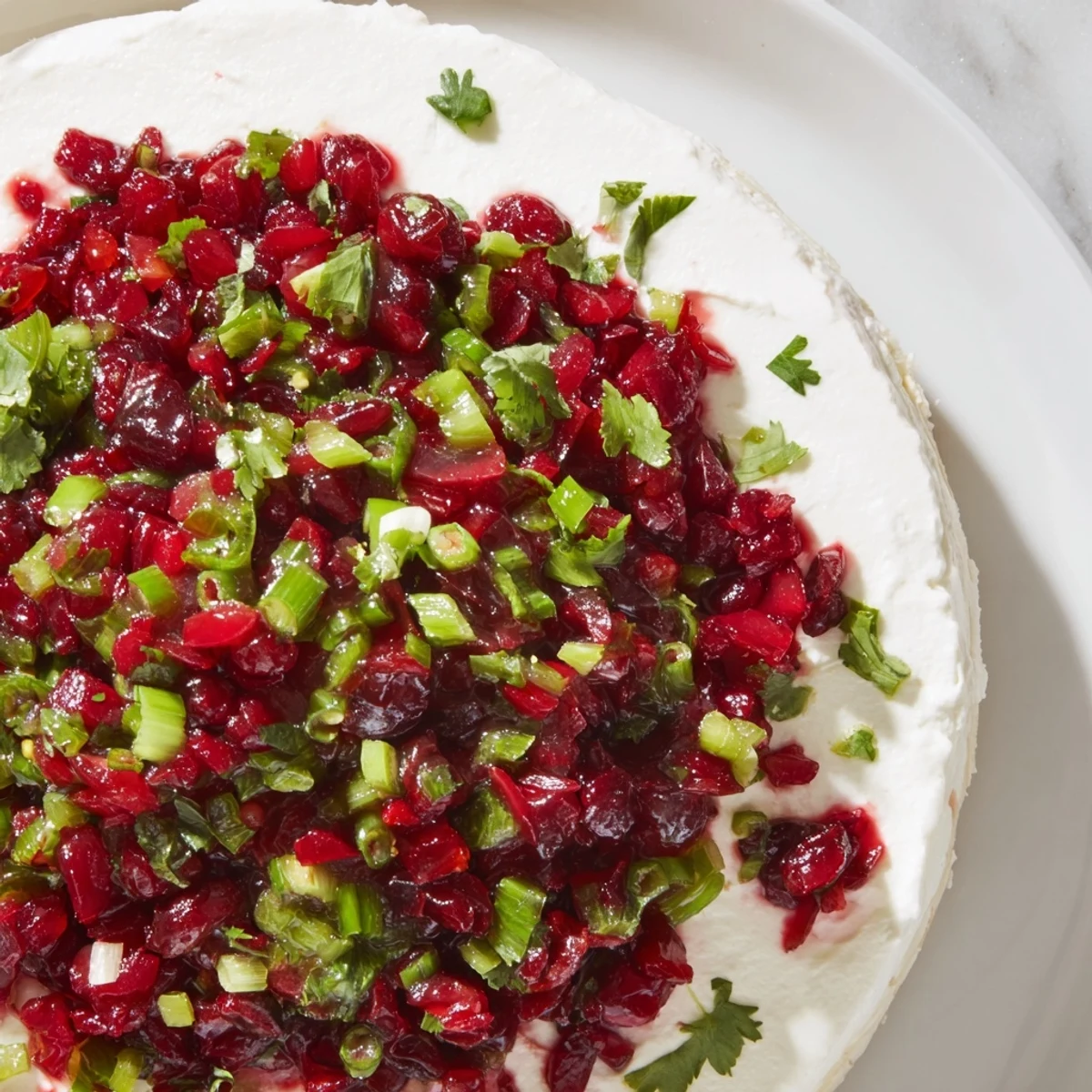 Spiced Cranberry Jalapeño Cream Cheese Dip: A festive appetizer featuring a luscious creamy base and vibrant toppings.