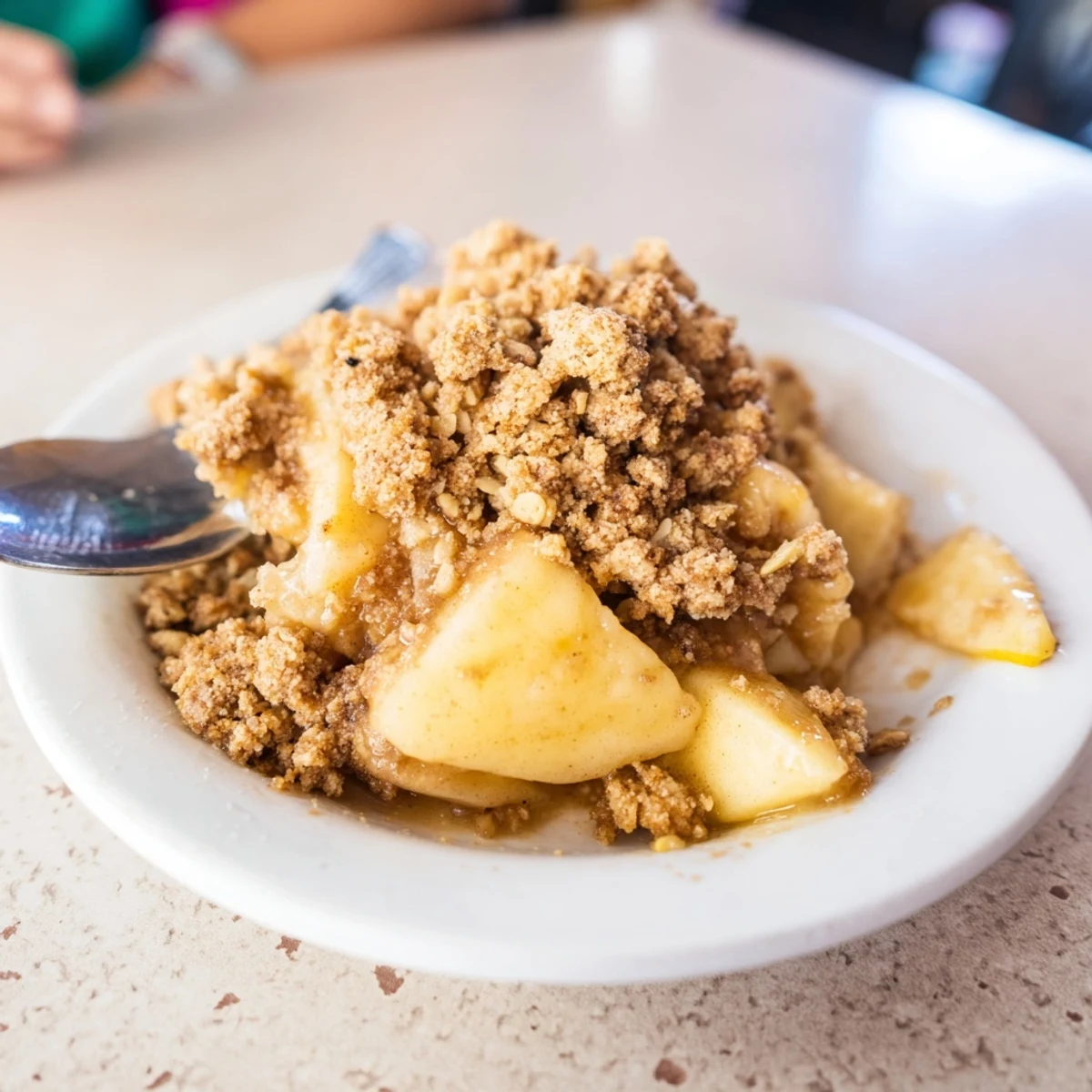 A close-up of baked Apple Crisp; the aroma of cinnamon and apples fills the air.