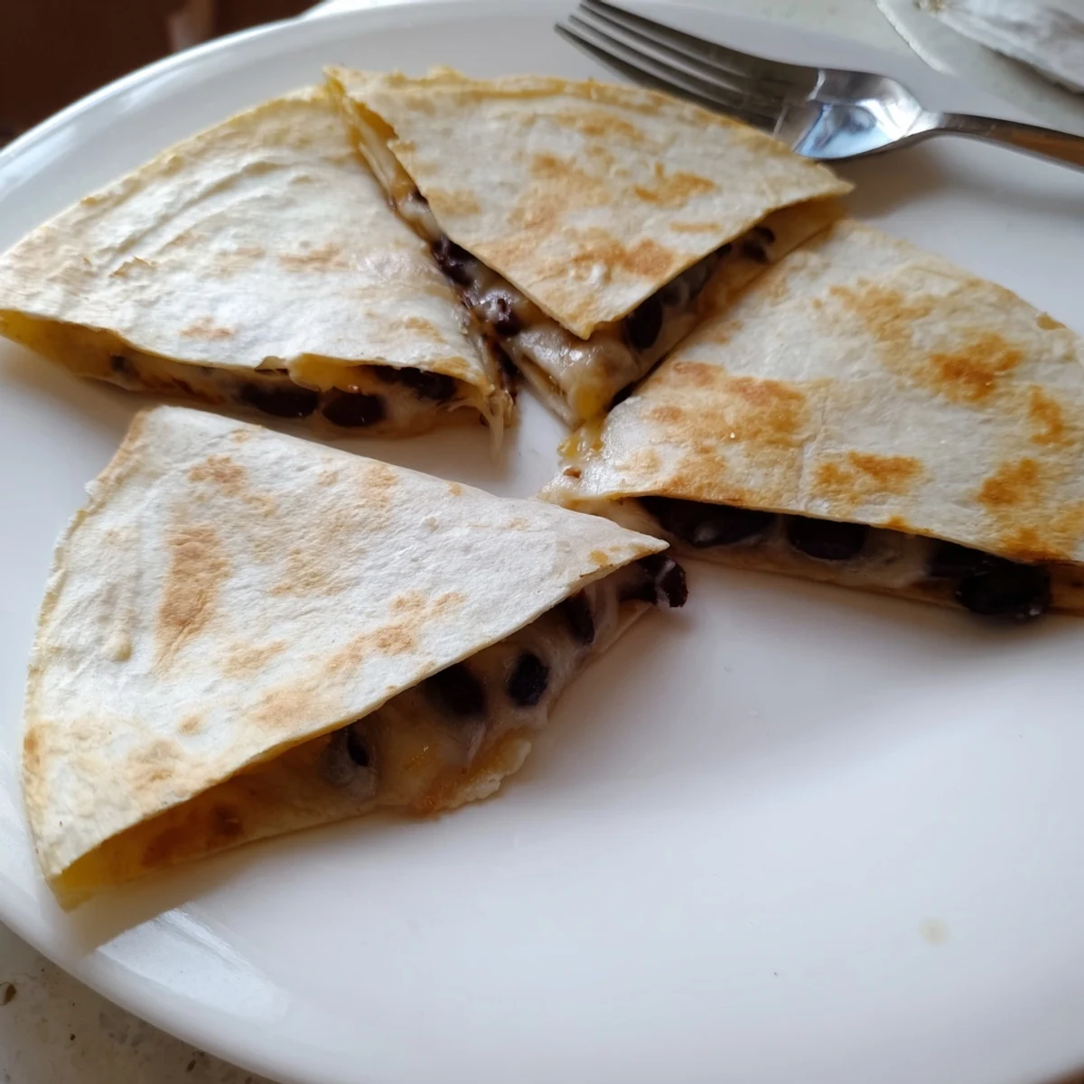 Warm, melty cheese oozes from inside a crispy Bean & Cheese Quesadilla, ready for dipping and enjoying.
