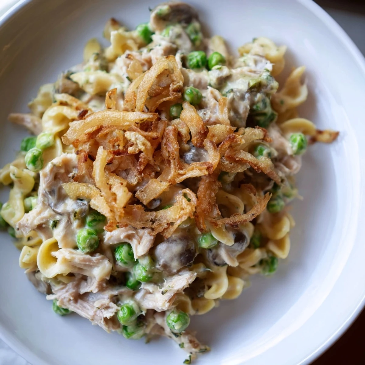Golden, bubbly homemade tuna noodle casserole with crispy onion topping, ready to serve and enjoy.