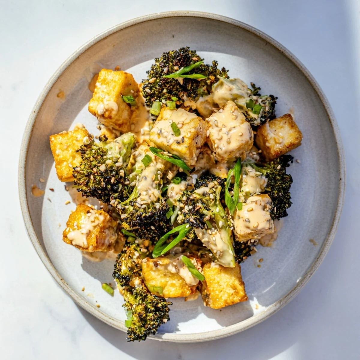 Golden, crispy Cheesy Baked Tofu and Broccoli, served in a creamy, bubbling sesame-ginger sauce.