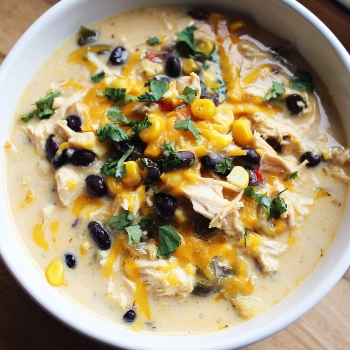Steaming hot Chicken Poblano Soup, garnished with fresh cilantro, ready for a comforting meal.