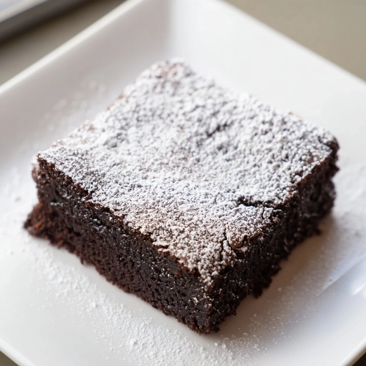 Warm, rich brownie squares, freshly baked and lightly dusted with powdered sugar for a delightful treat.
