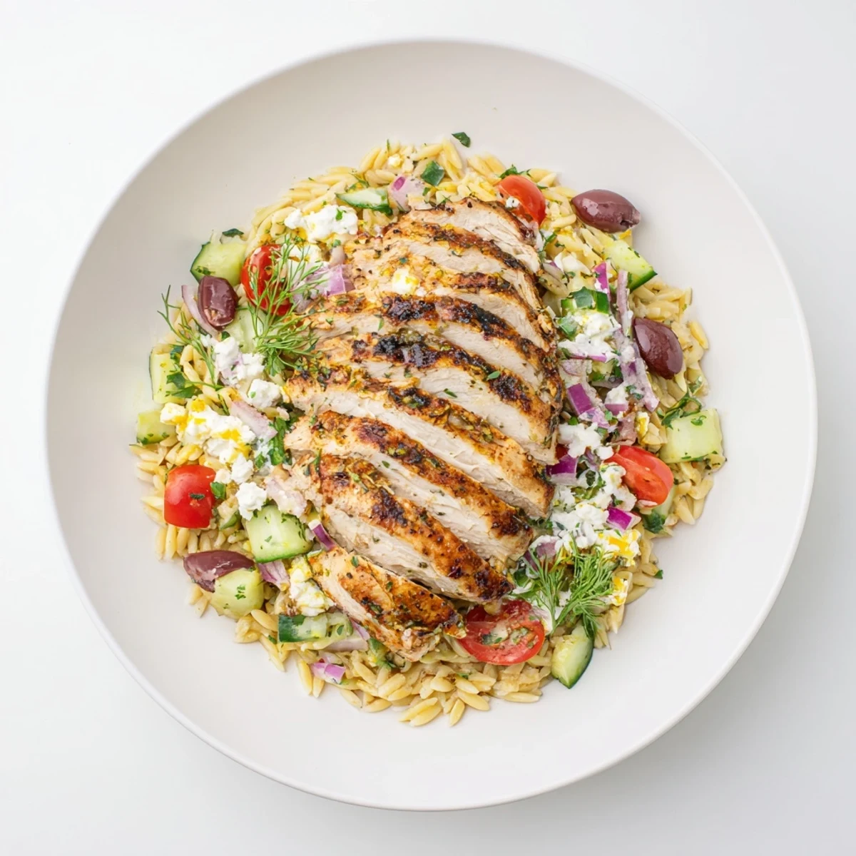 Greek Chicken Gyro Pasta Bowls boast grilled chicken, flavorful orzo, and creamy feta-yogurt sauce—a delicious Mediterranean meal.