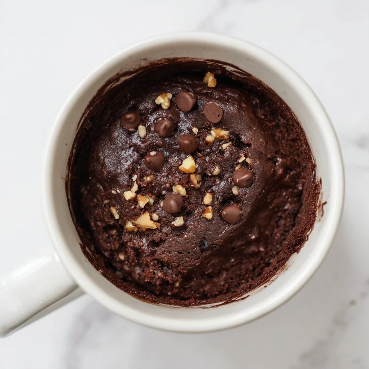Warm, fudgy 2-minute Mug Brownie, garnished with chocolate chips, ready for a quick dessert.