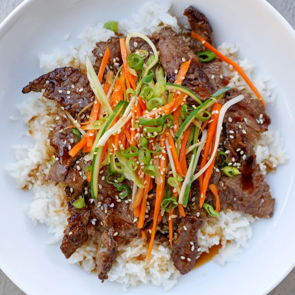A steaming bowl of bulgogi with tender beef, rice, and crisp, colorful stir-fried vegetables for dinner.