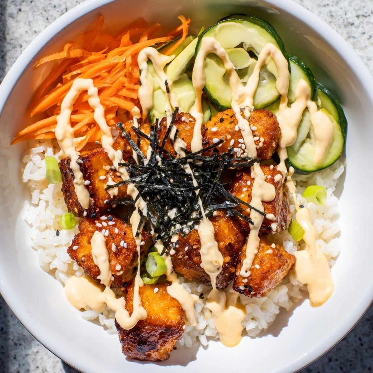Crispy golden salmon bites bowl, a colorful plate of rice, avocado, and spicy mayo.