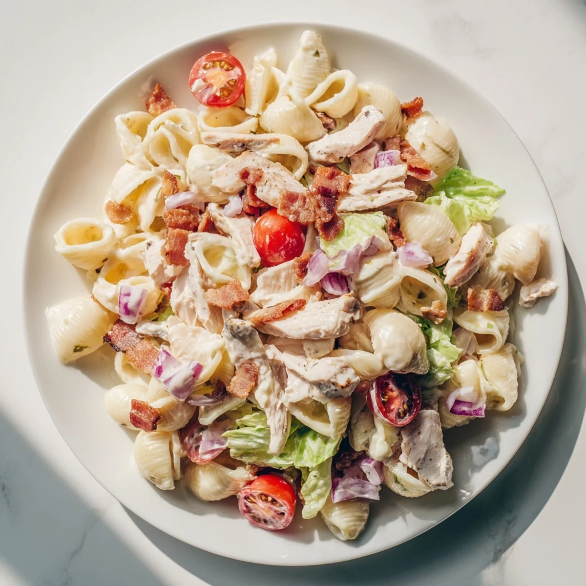 A close-up of delicious BLT Chicken Pasta Salad, showing off the perfectly cooked chicken and bacon.