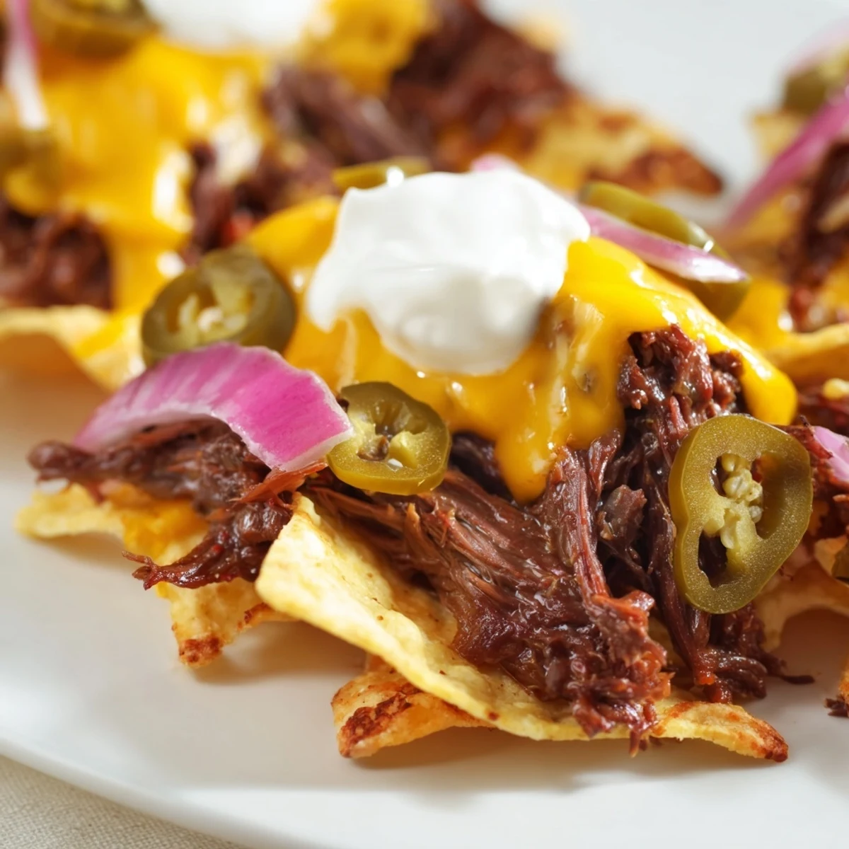 Sizzling BBQ beef nachos emerge from the oven with gooey cheese, pickled jalapeños, and diced tomatoes.