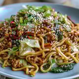 Sizzling ground turkey and crisp vegetables mingle in a wok with pan-fried noodles for a quick, savory dinner.