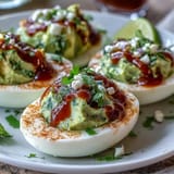 Vibrant avocado deviled eggs topped with zesty Sriracha sauce, an easy gluten-free appetizer.