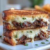 Golden-brown sourdough hugs slow-cooked short ribs for the perfect short rib grilled cheese.