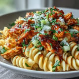 Flavorful No-Bake Buffalo Chicken Pasta topped with fresh celery and green onions.