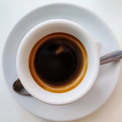 Freshly brewed coffee in a mug, steaming and rich with deep aroma.  