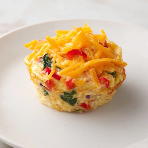 Golden, baked Easy Christmas Morning Egg Muffins bursting with colorful veggies and melted cheese, ready to enjoy.
