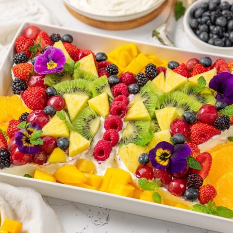 Vibrant Butterfly Garden Fruit Board, featuring colorful berries, pineapple, and a creamy yogurt dip.