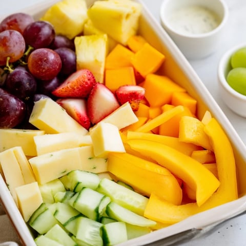 Vibrant Sunshine Snack Tray: Colorful fruits, veggies, cheese and dips offer a taste of sunshine.