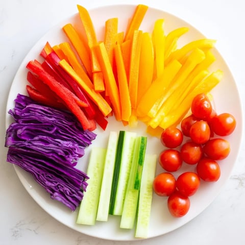 Colorful rainbow arch veggie sticks; a vibrant, healthy snack with fresh bell peppers and carrots.
