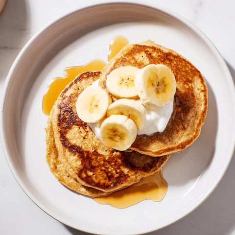 Golden-brown Protein Banana Pancakes, ready to be flipped on the skillet for a healthy breakfast.