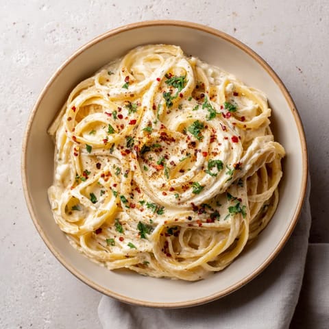 A bowl of pasta with red peppers and cheese.