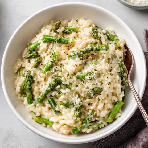 A bowl of rice with asparagus and cheese.
