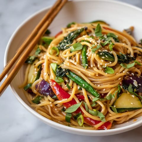 A bowl of noodles with vegetables.