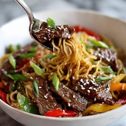 A bowl of noodles with meat and vegetables.
