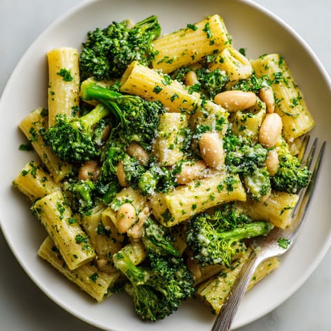 A plate of pasta with broccoli and beans.