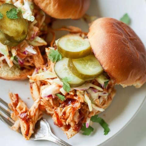 Close-up of juicy, shredded Cajun BBQ Chicken Sliders, perfect for game day snacking.