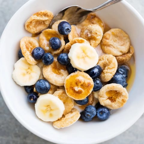 Adorable Mini Pancake Cereal stacked high, crispy outside and fluffy inside, ready to enjoy.  