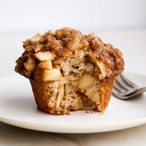 Tender apple muffins with a caramelized cinnamon topping, ideal for a cozy snack.  