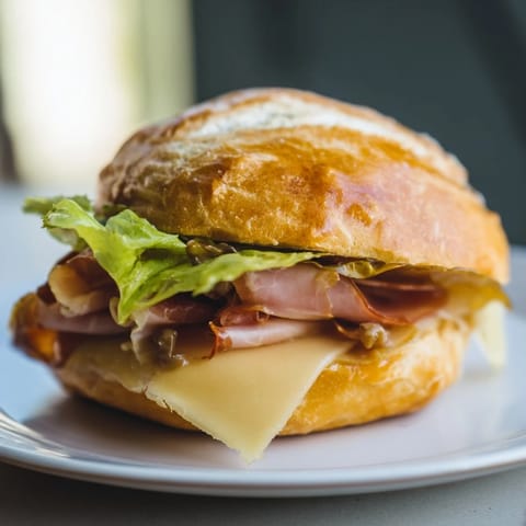 Festin du Château Royal sandwiches feature layers of ham, cheese, and fresh greens, ready to enjoy.