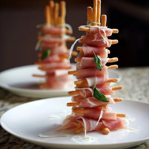 Golden Gate appetizer: Crispy breadsticks act as towers with prosciutto draped, a savory, quick party snack.