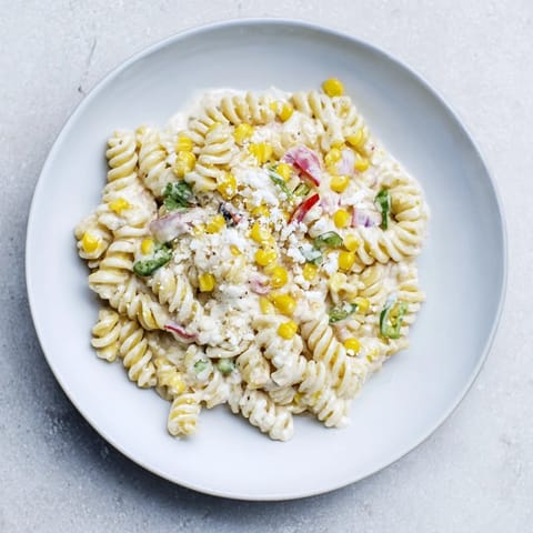 Bright and colorful One-Pot Mexican Street Corn Pasta, ready to eat with a squeeze of lime.