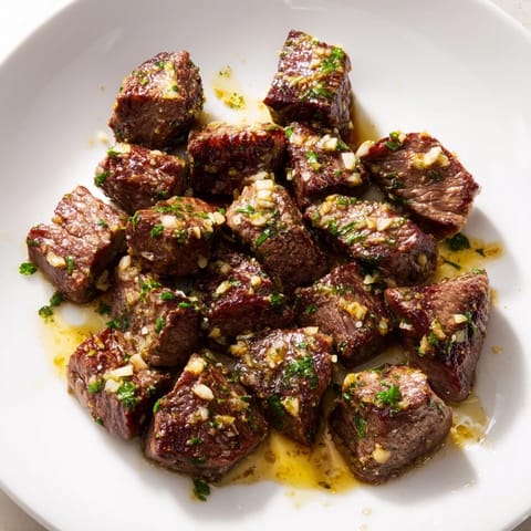 Close-up of golden brown air fryer garlic-butter steak bites, a delicious main dish option.