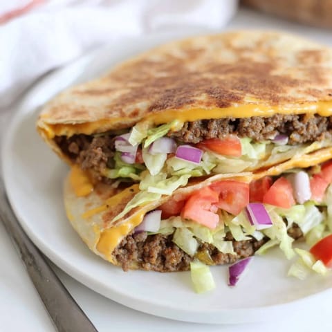 A close-up of a perfectly grilled Taco Bell Crunchwrap Supreme, ready to be sliced and enjoyed.