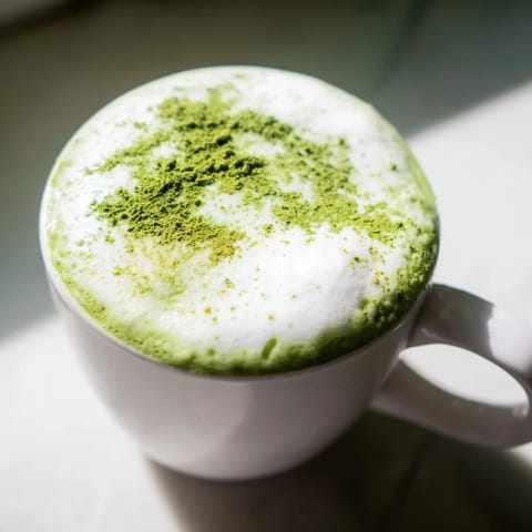 Vivid green Matcha Green Tea Latte poured into a white mug, ready to be enjoyed.