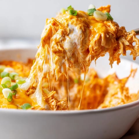 Crock Pot Buffalo Chicken Dip bubbling in a slow cooker with shredded chicken, buffalo sauce, and ranch, served with celery sticks.