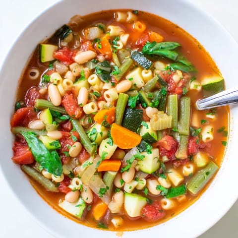 Garnished with fresh parsley and a side of crusty bread, this hearty Italian Minestrone Soup is a comforting, wholesome meal.  