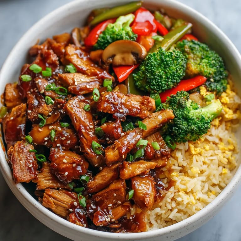 A bowl of food with meat, broccoli, and peppers.