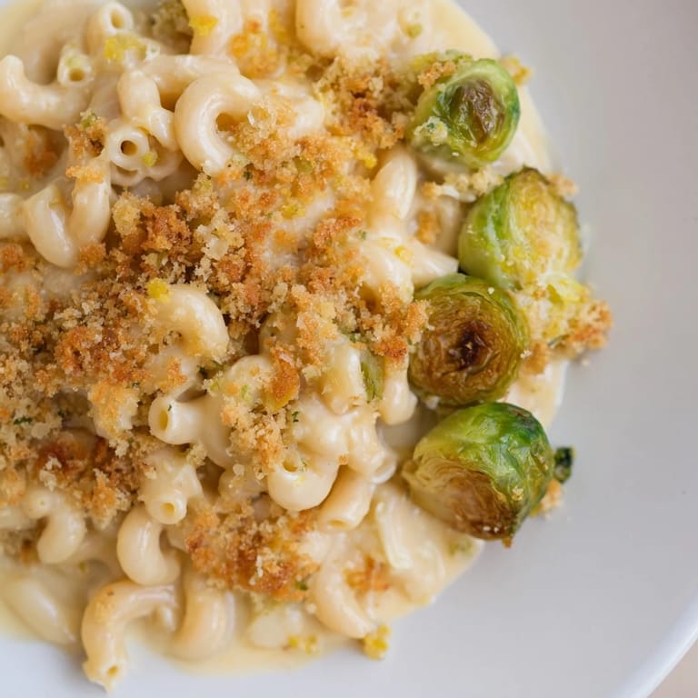 Crispy Brussels sprouts surround a generous serving of sheet pan mac and cheese, ready to eat.