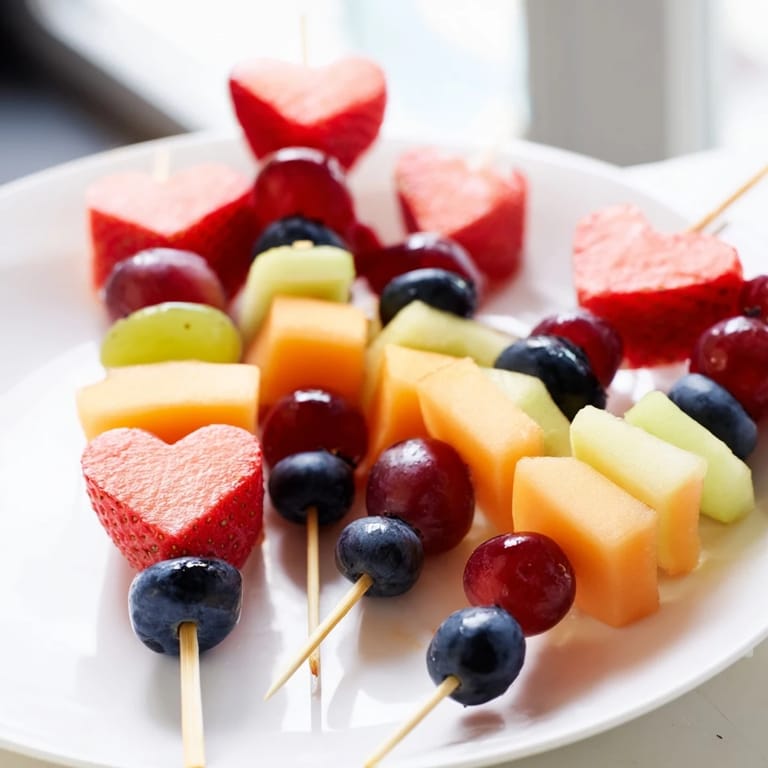 Cool and refreshing Berry Good Heart Fruit Skewers offer a rainbow of flavors, ideal for any fruity celebration.