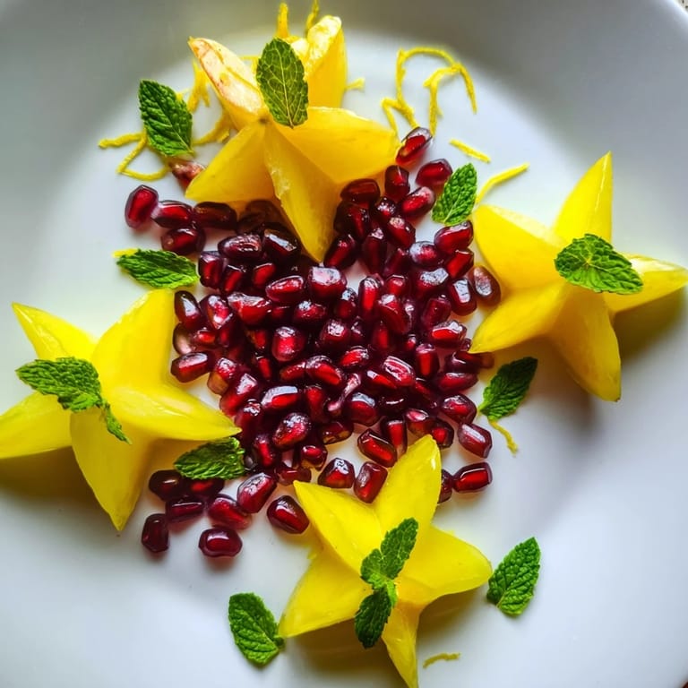 Freshly assembled pomegranate and mint star fruit platter, a refreshing and visually stunning fruit dish.