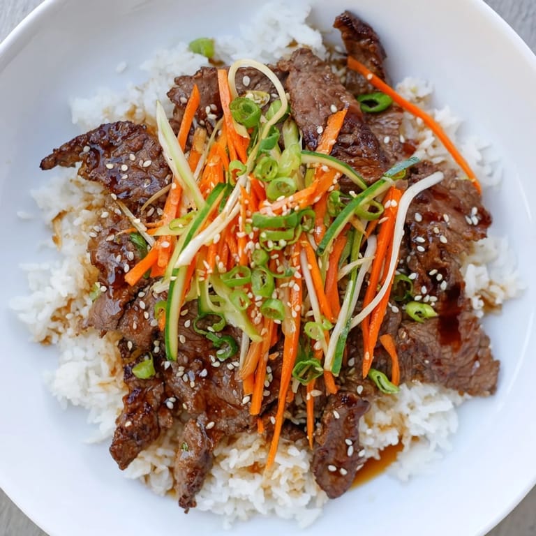 A steaming bowl of bulgogi with tender beef, rice, and crisp, colorful stir-fried vegetables for dinner.